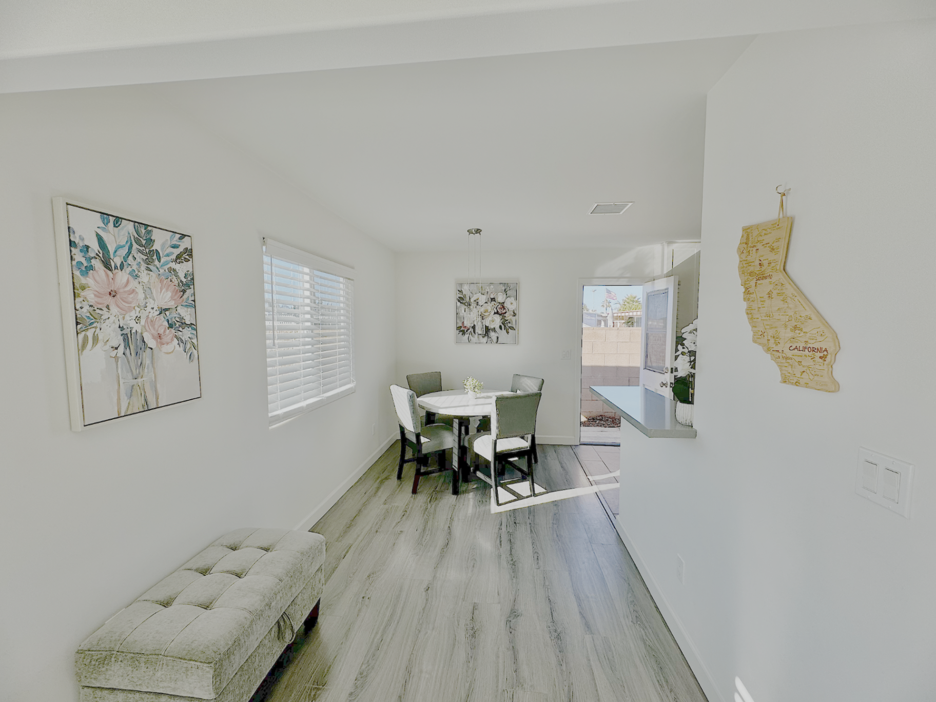 Bright Oceanside breakfast area with dining table and coastal artwork